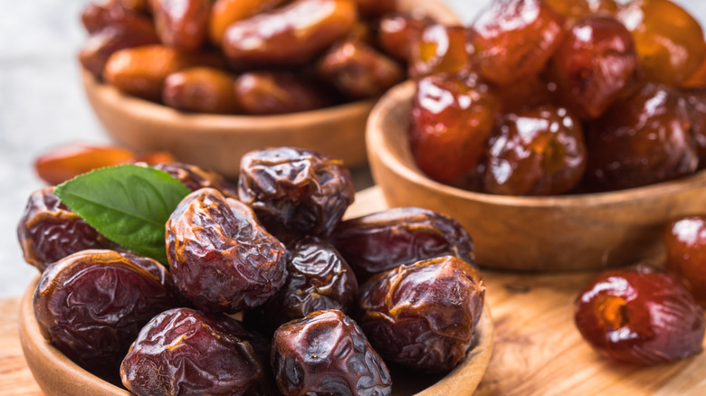 three wooden bowls filled with dates