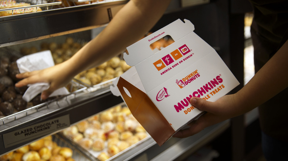 Dunkin' employee filling munchkin box 