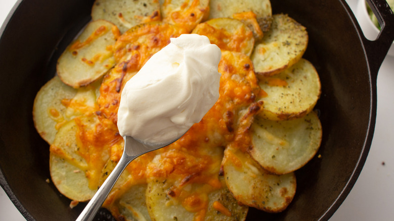 topping nachos with sour cream