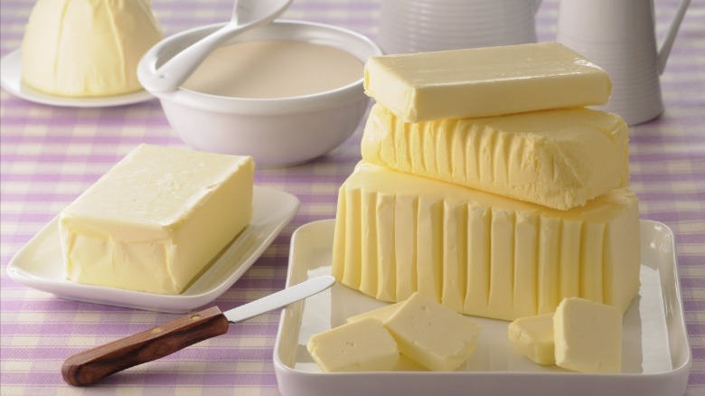 Different blocks of butter on tablecloth