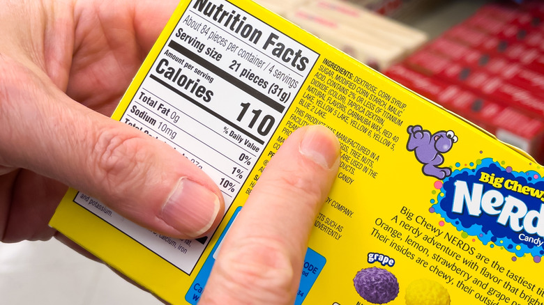 A box of Nerds candy with a finger pointing to yellow 6 and yellow 5 as ingredients.
