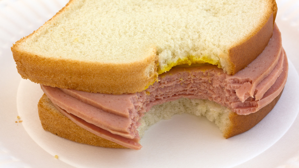 Bitten bologna sandwich with mustard