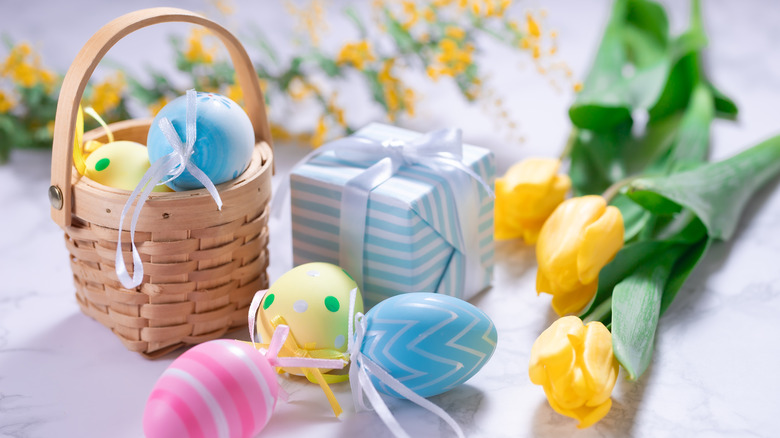Easter eggs with yellow tulips on marble background