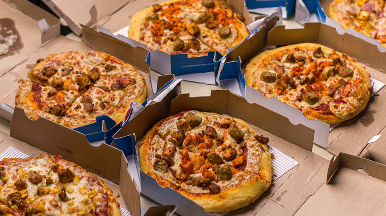 an array of Domino's pizzas in cardboard takeout boxes