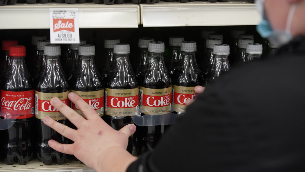 man reaching for diet soda