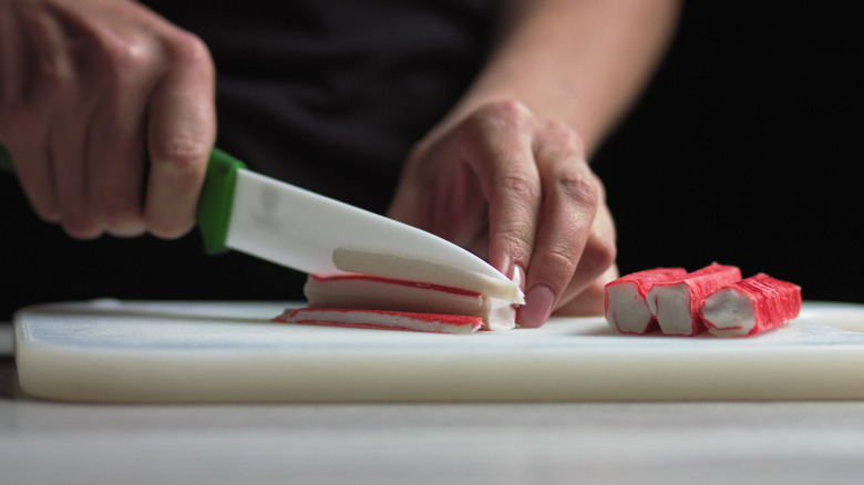Slicing imitation crab on cutting board
