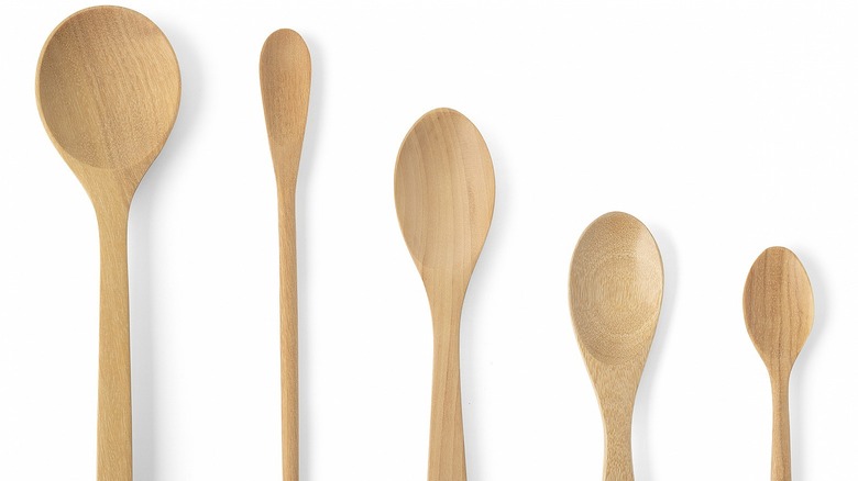 Five different sized and shaped wooden spoons.