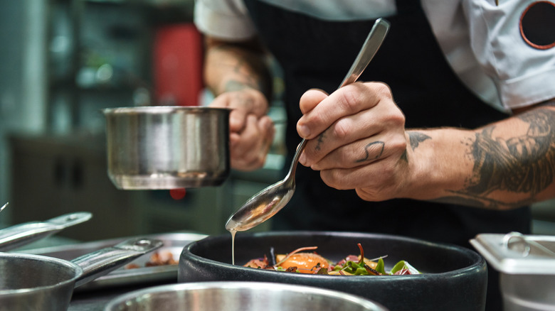 Chef pouring sauce with spoon