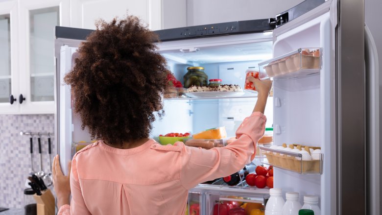 Woman putting food in the refrigerator