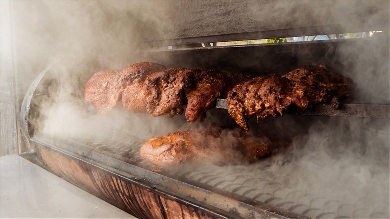 Meats cooking inside a smoker