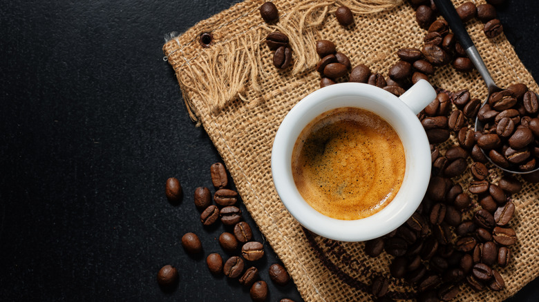 A cup of espresso with coffee beans