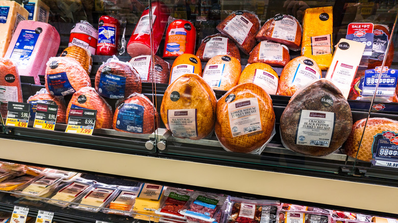 Deli meats and cheeses in a supermarket deli display case