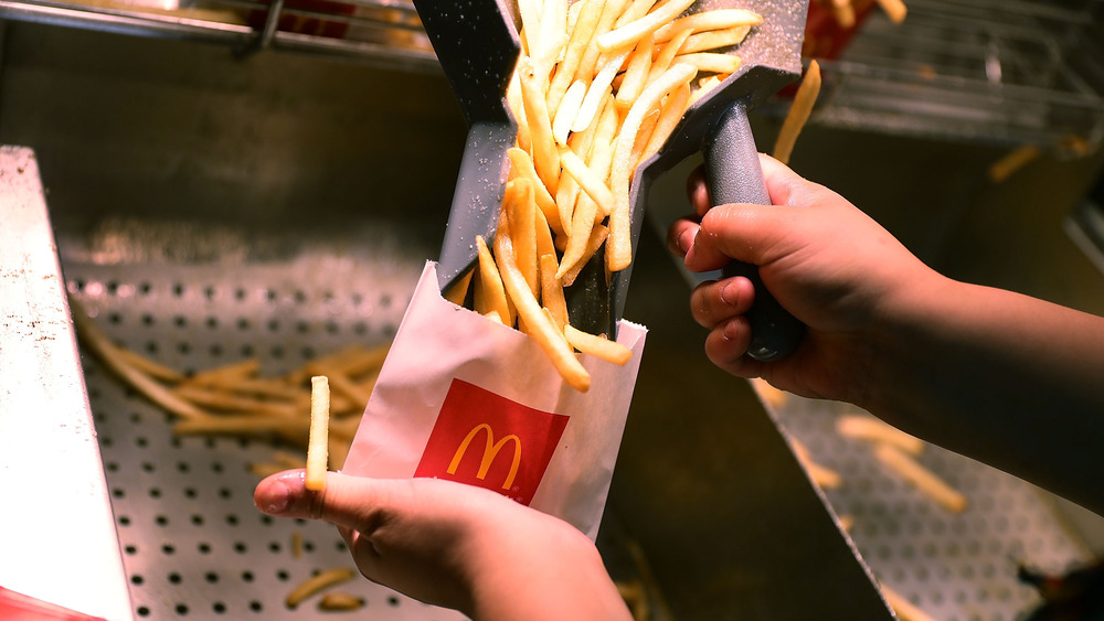 McDonald's employee filling a bag with French fries