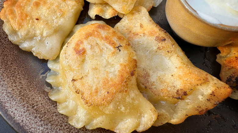 A plate of pierogies with sour cream