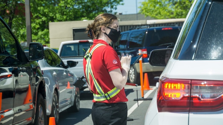 Employee taking order at a drive-thru