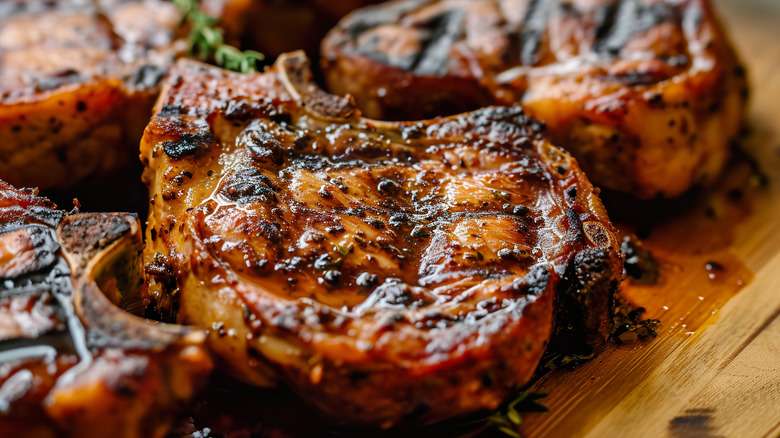 Grilled pork chops on wooden surface