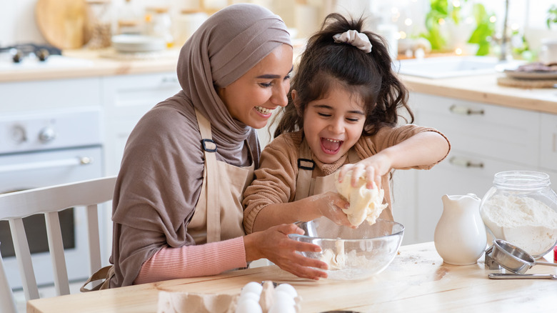 mom and daughter mixing dough 