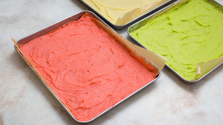 colored cake batter in pans