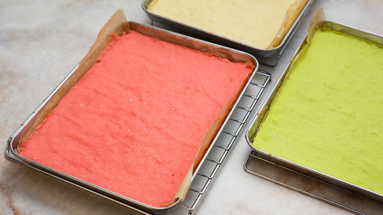 colored cakes cooling in pans