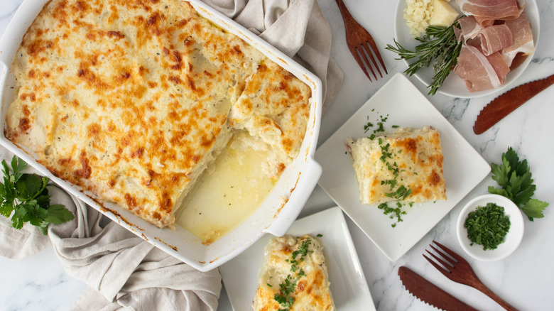 Scalloped potatoes in casserole dish next to servings on plates