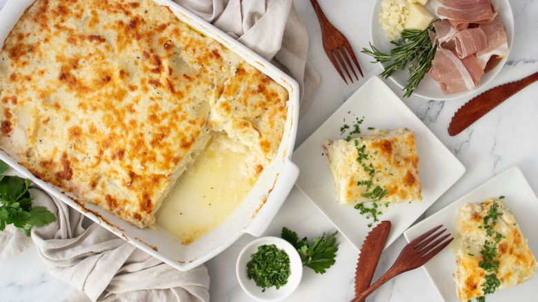 Scalloped potatoes in casserole dish next to servings on plates