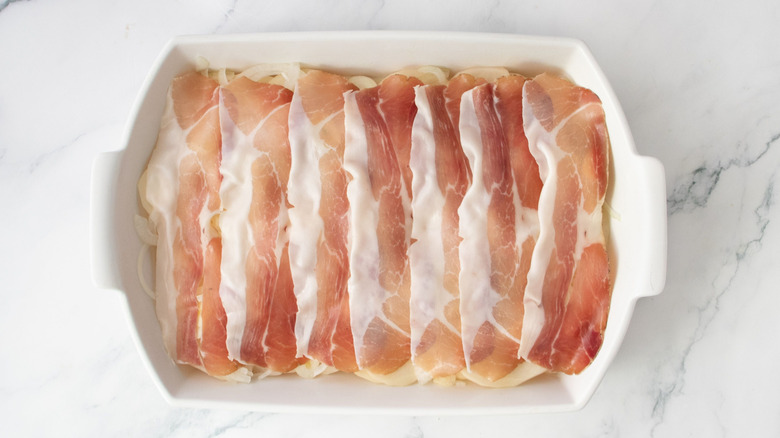Prosciutto slices layered in casserole dish