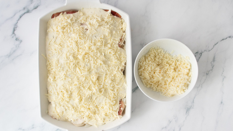 Cheese-topped casserole next to bowl of cheese