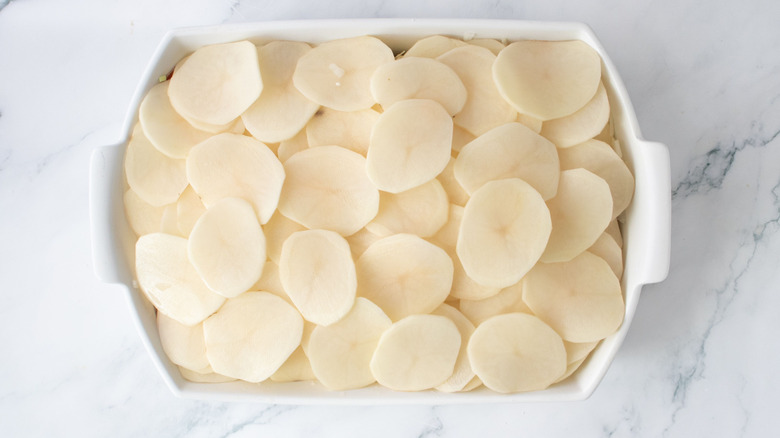 Unbaked scalloped potatoes in casserole dish
