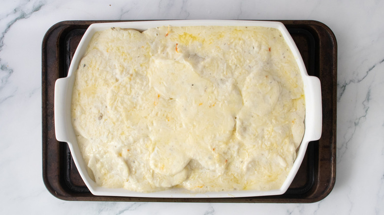 Partially baked scalloped potatoes in casserole dish