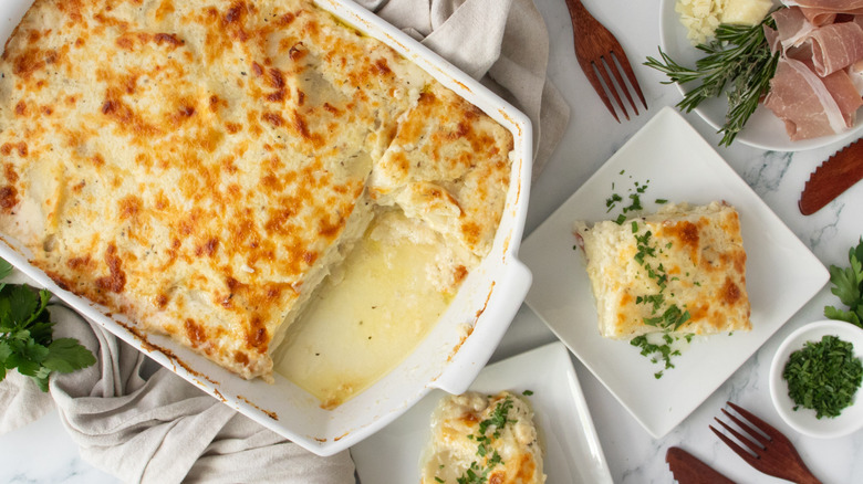 Scalloped potatoes in casserole dish next to servings on plates