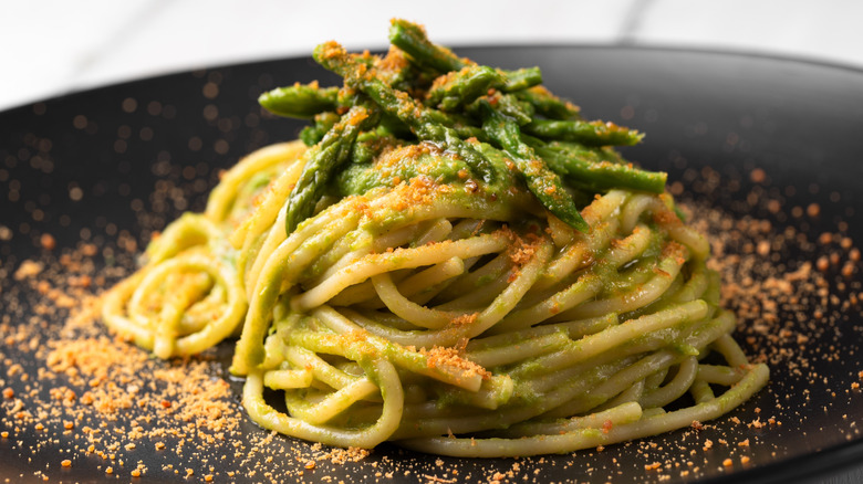 Plate of pasta topped with asparagus