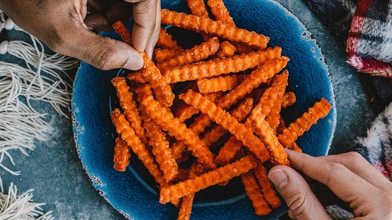 Hands reaching for sweet potato fries