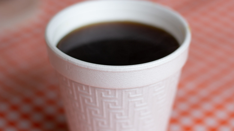 Styrofoam cup of coffee on a classic red tablecloth