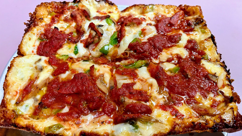 Detroit pizza on a pink background