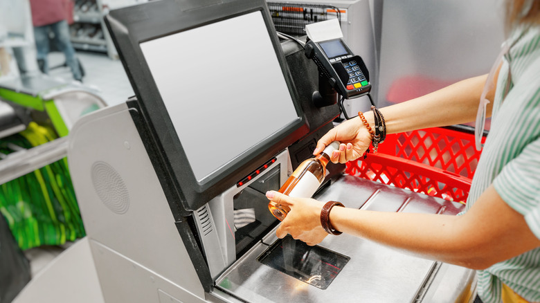 Woman scanning bottle of alcohol