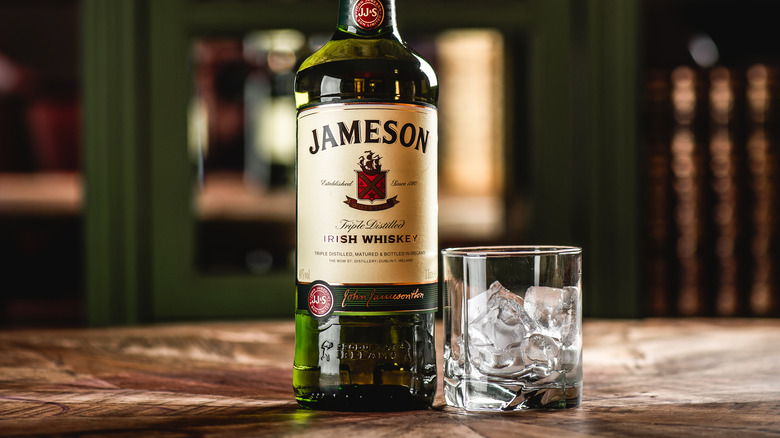 A full bottle of Jameson Irish Whiskey with a glass of ice