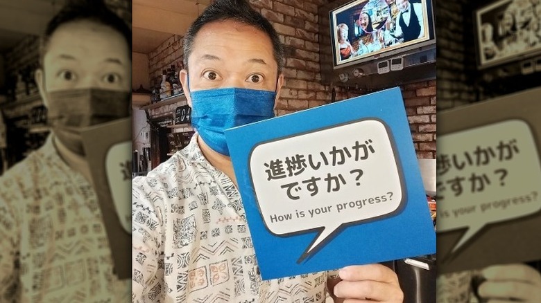 Cafe owner holding up progress sign