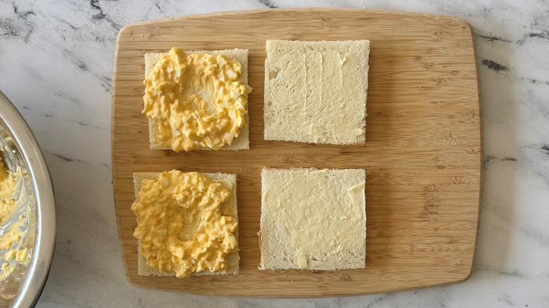 Open faced egg salad sandwiches with wells pressed into egg salad