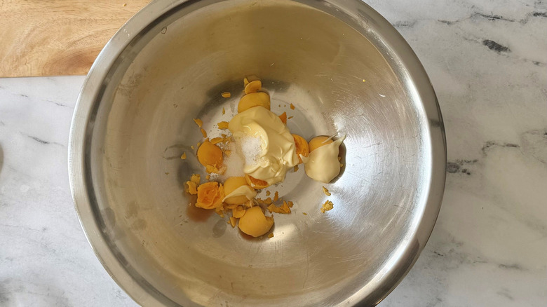 Egg yolks, mayonnaise, sugar, and salt in bowl