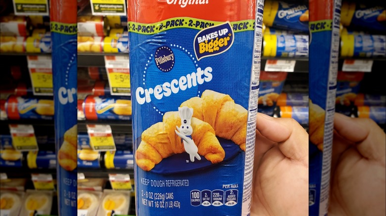 Hand holding up a 2-pack of Pillsbury crescent roll dough
