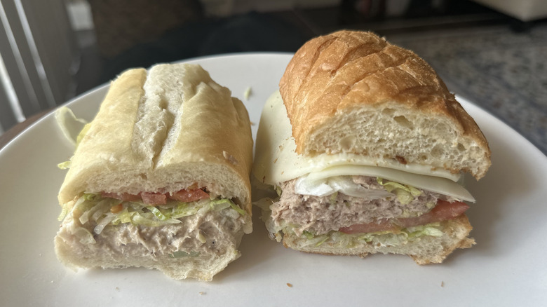 Side by side tuna subs on white plate