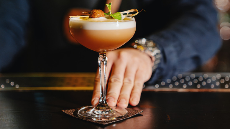 A bartender serving a classic daiquiri