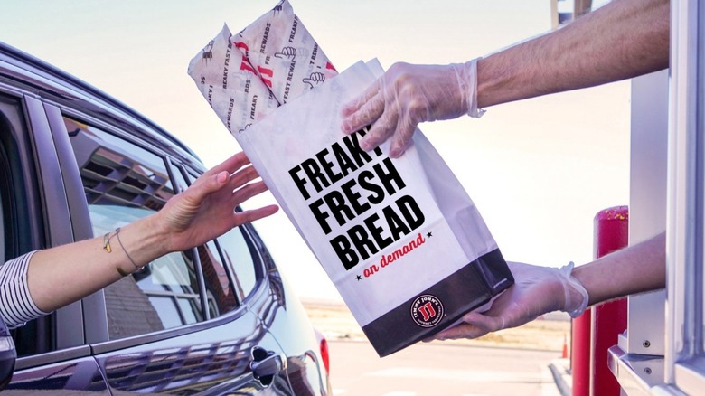 Jimmy John's employee handing over bag in drive-thru