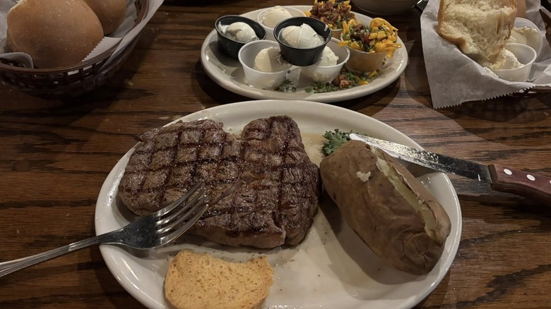 Steak dinner with baked potato and fixings