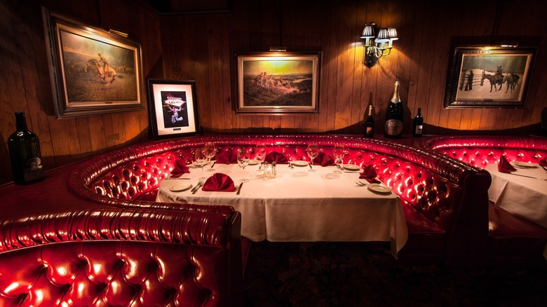 A red leather booth with a set table
