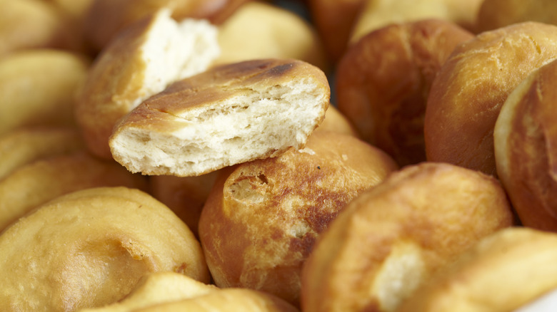 A pile of thick and fluffy johnnycakes with one sliced in half on top