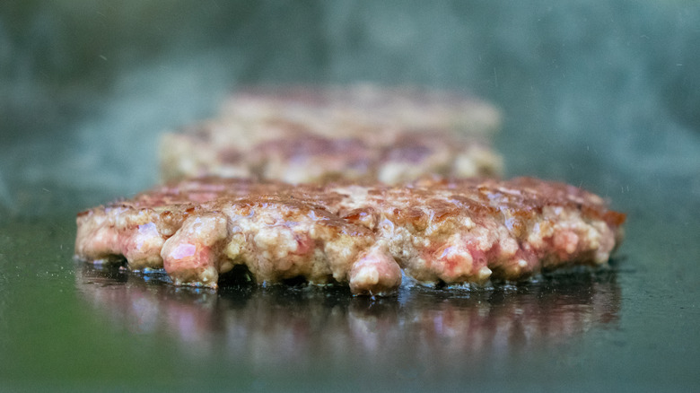 Burger patty cooking on grill top