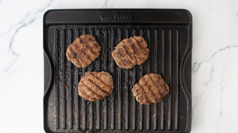 Cooked lamb burgers on grill pan