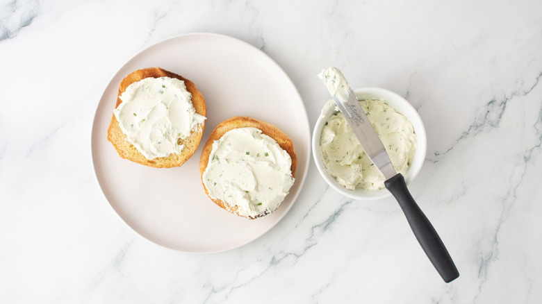 Goat cheese spread onto burger buns
