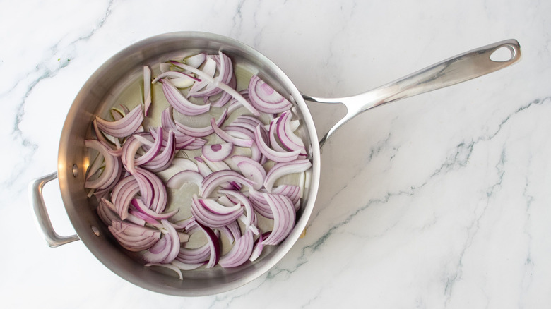 Sliced red onions in saucepan